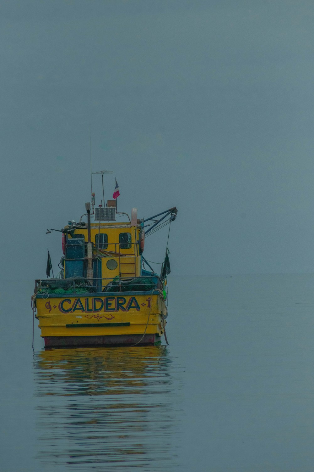 a yellow boat floating on top of a body of water