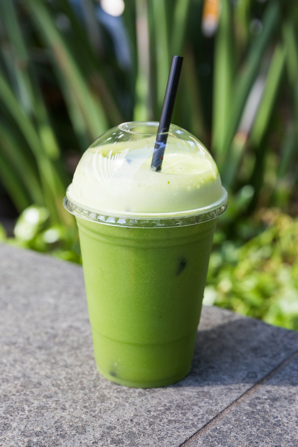 green and white plastic cup with black straw