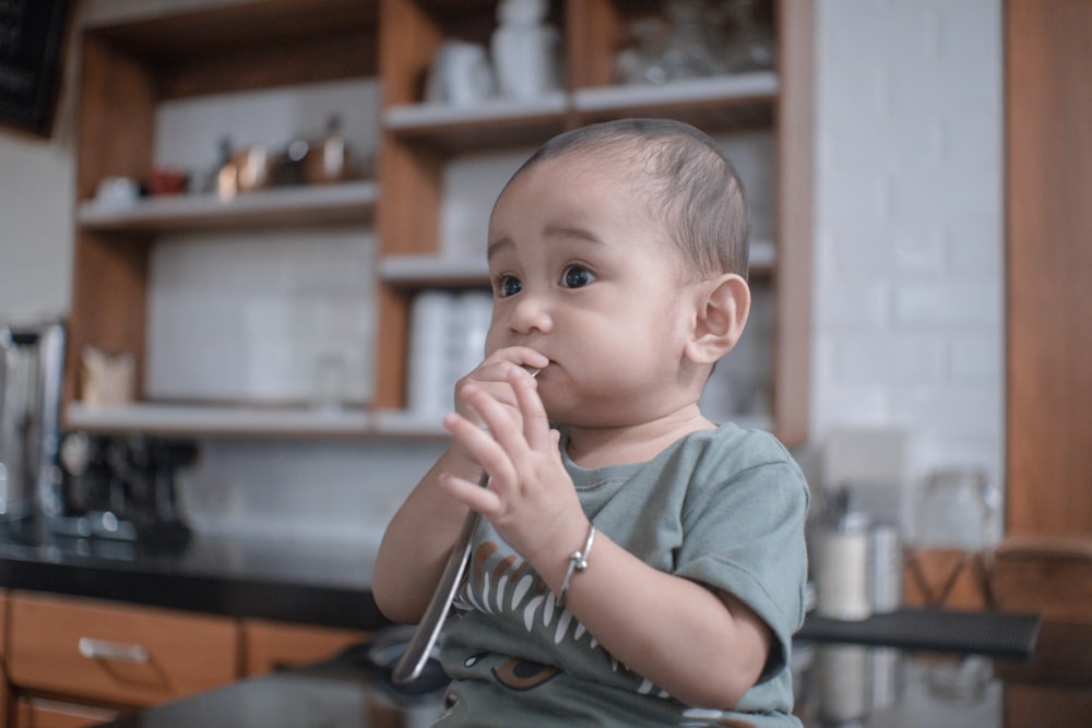 a small child sitting on a chair in a kitchen