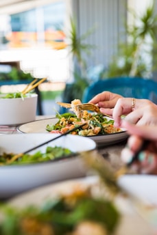 person holding brown and green vegetable dish