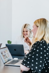 A smiling solo entrepreneur reviewing client details on a tablet in a bright room.