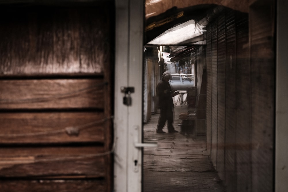 man in black jacket and pants standing in front of door