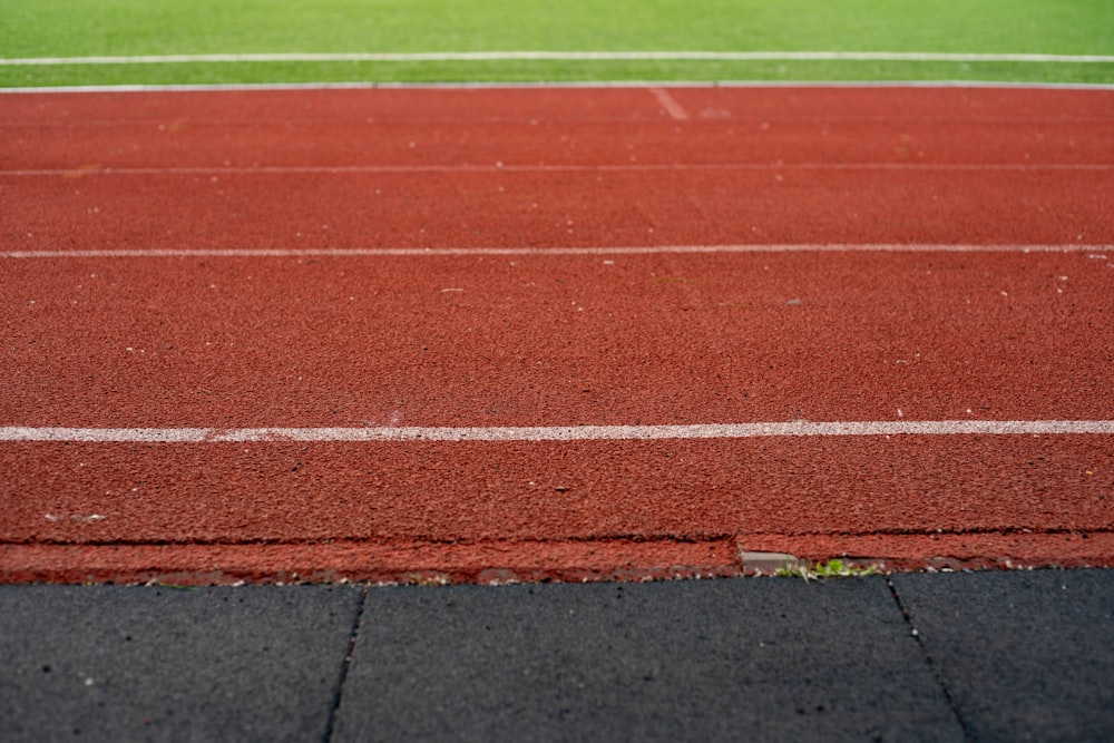 a close up of a running track with grass in the background