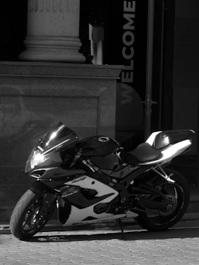 A sleek motorcycle parked outside a modern service center with a clear sign reading 'torvex moto'.
