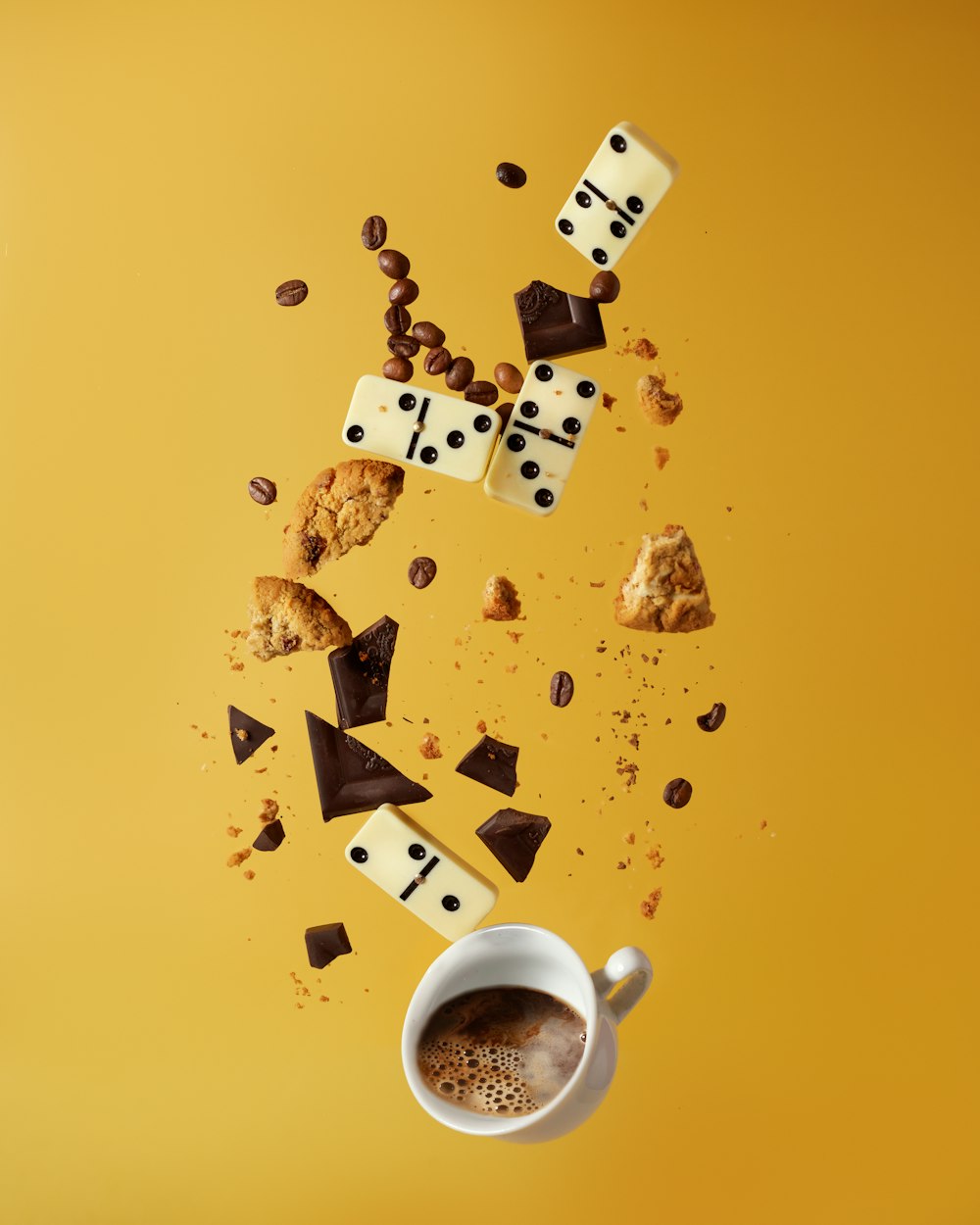 caneca de cerâmica branca com café ao lado de biscoitos marrons e brancos