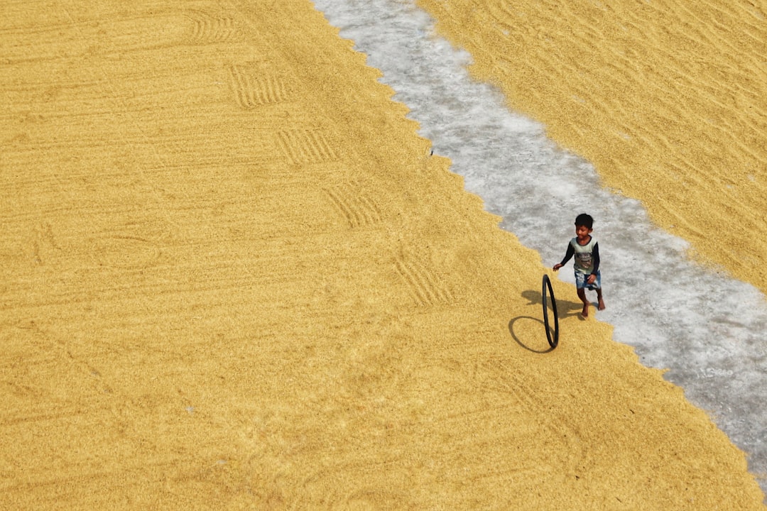 man in black shirt riding bicycle on brown sand during daytime
