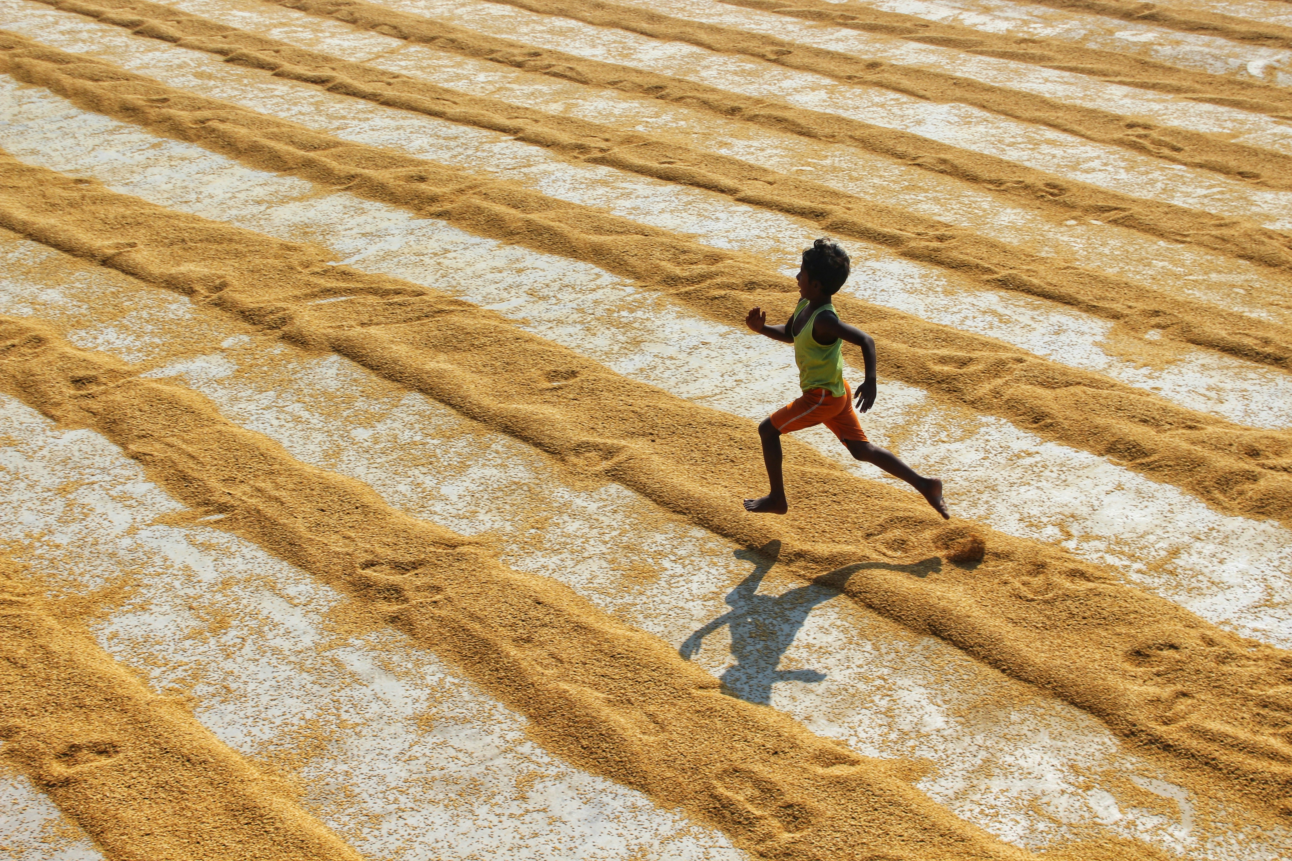 man in black shirt walking on brown sand during daytime