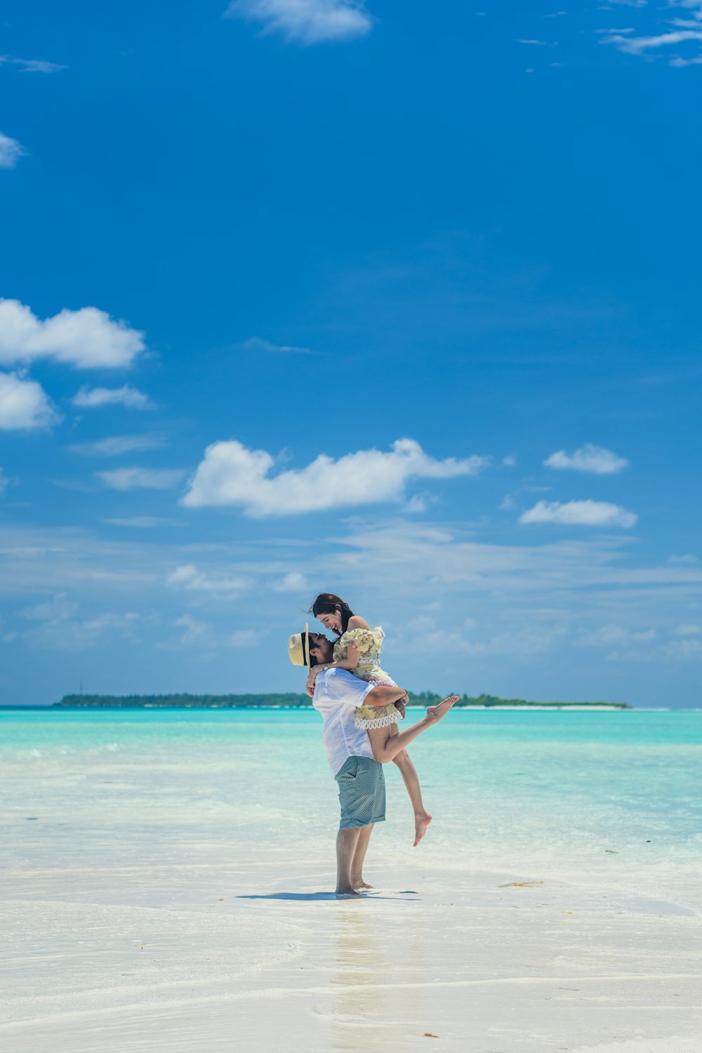 woman in white shirt and white shorts standing on beach during daytime