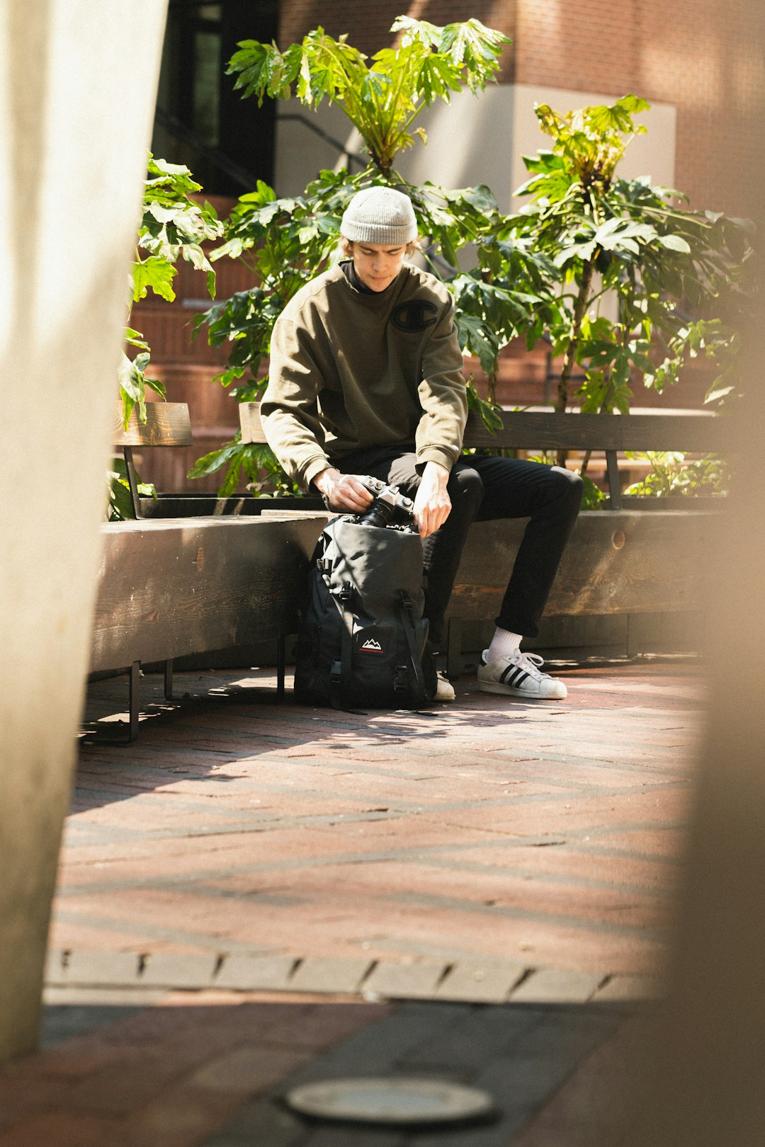 man in gray jacket and black pants sitting on bench