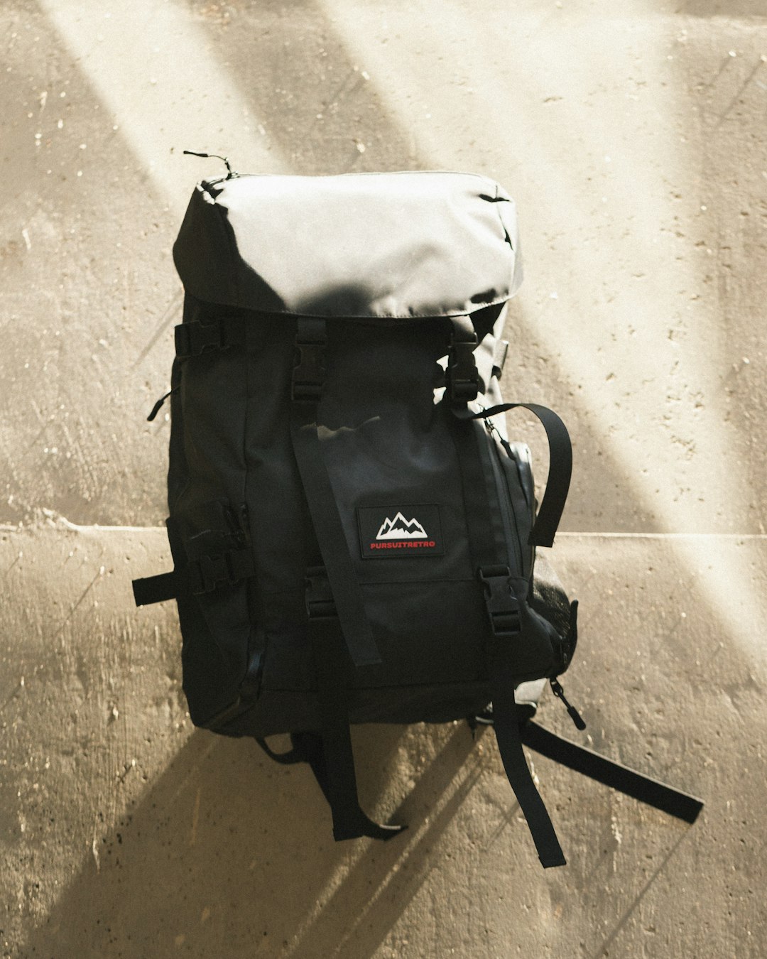 black and white backpack on brown wooden seat