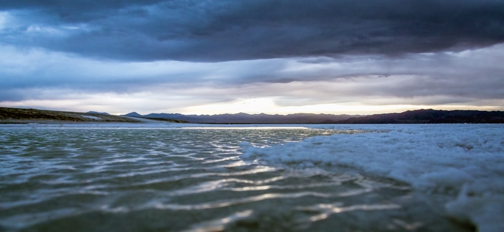 body of water under cloudy sky during daytime