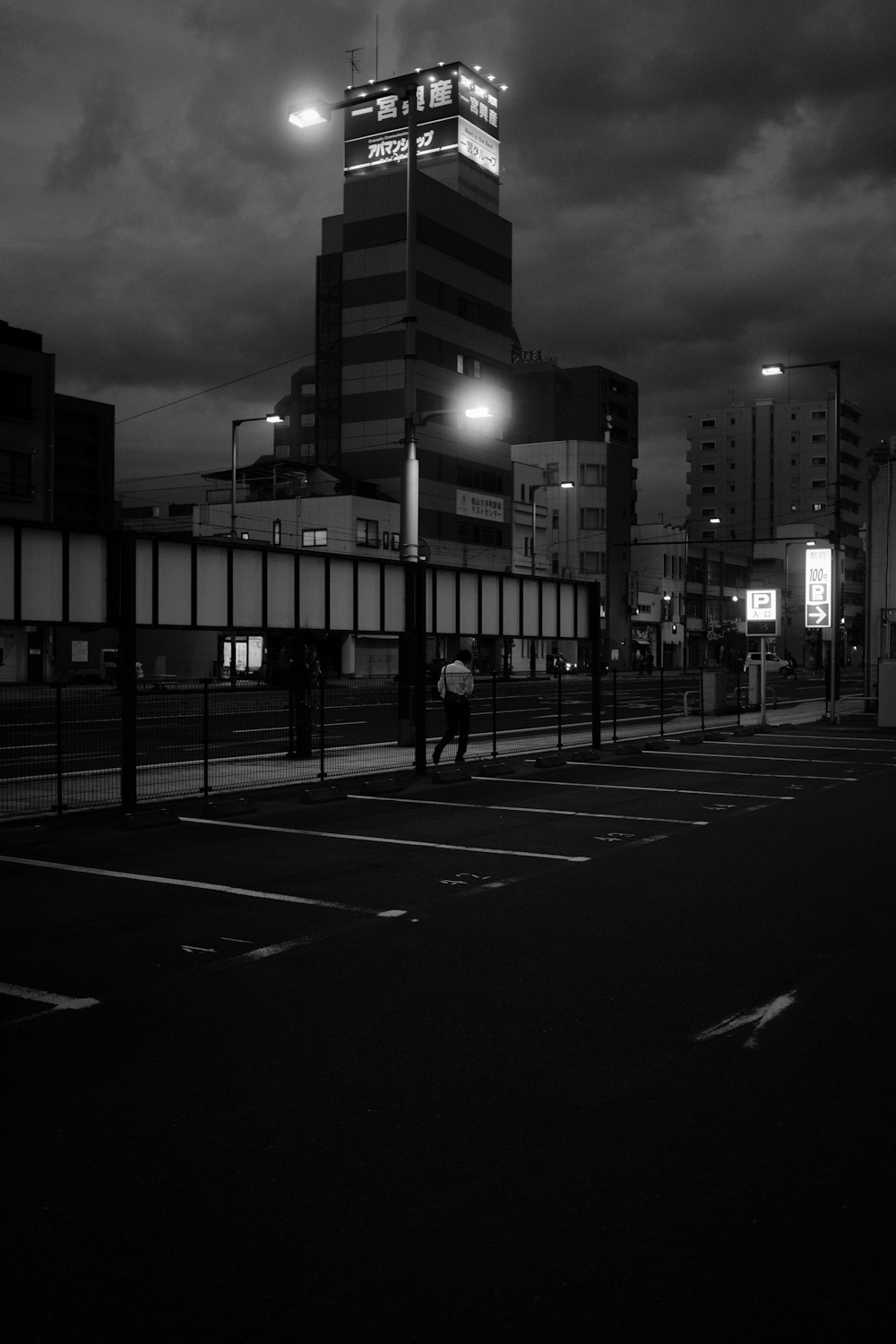 grayscale photo of people walking on sidewalk near high rise buildings