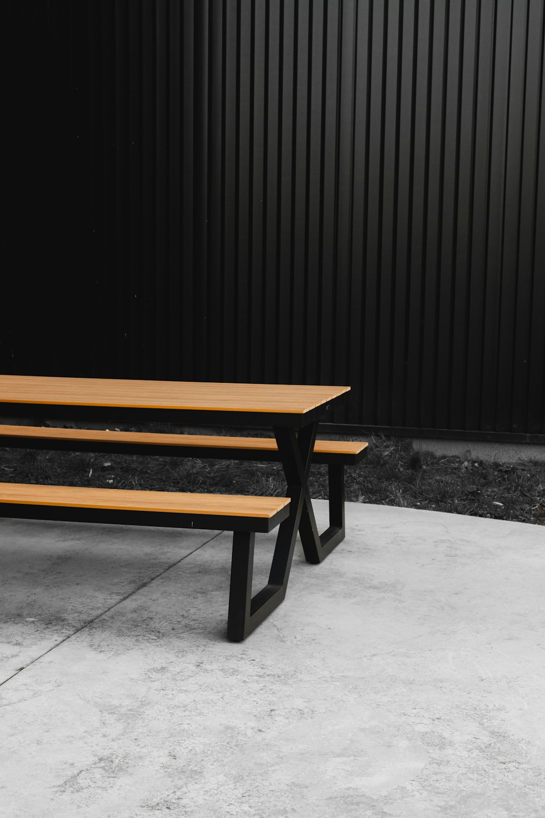 brown wooden bench near black wall