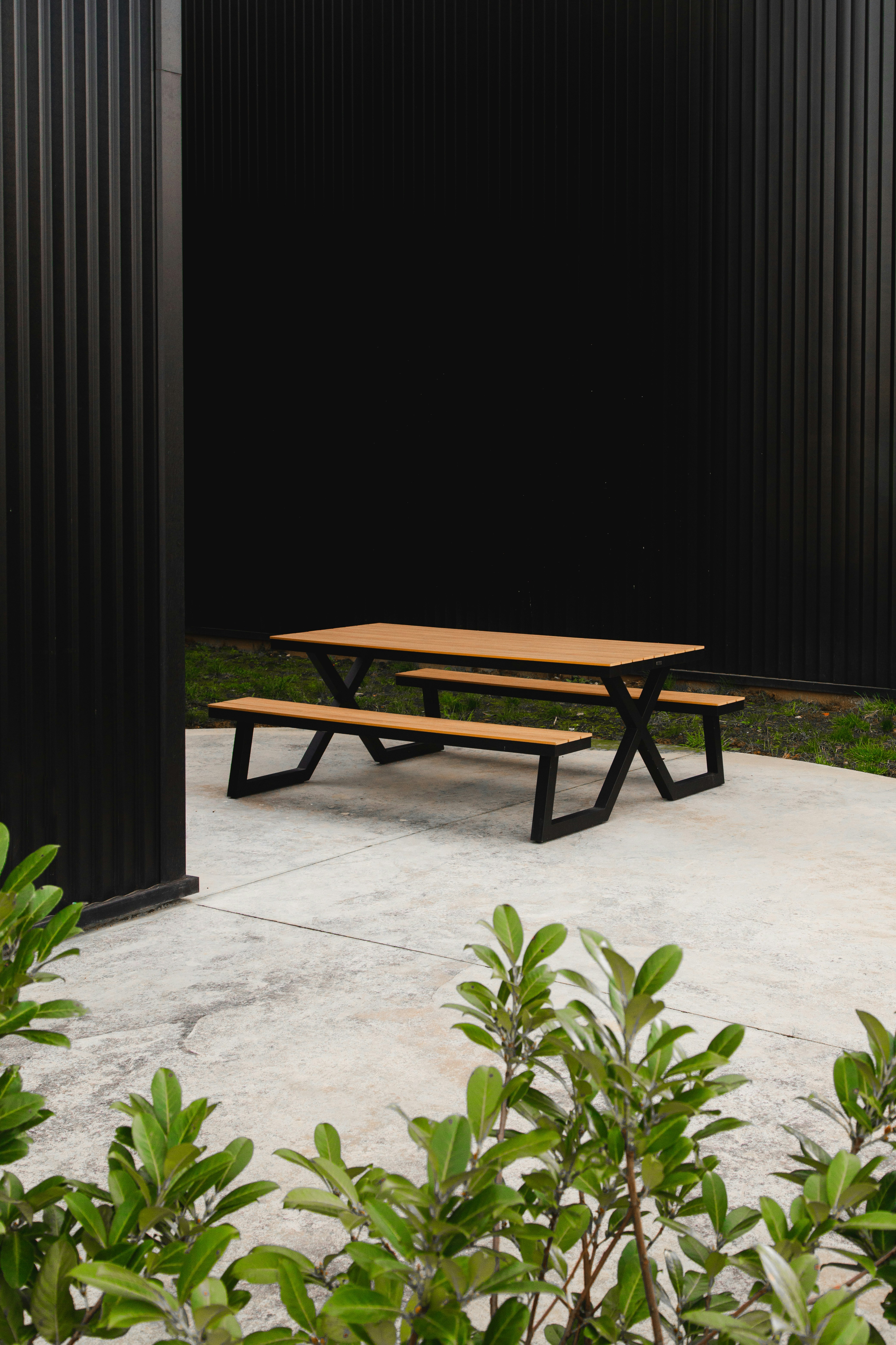 brown wooden table beside black wall