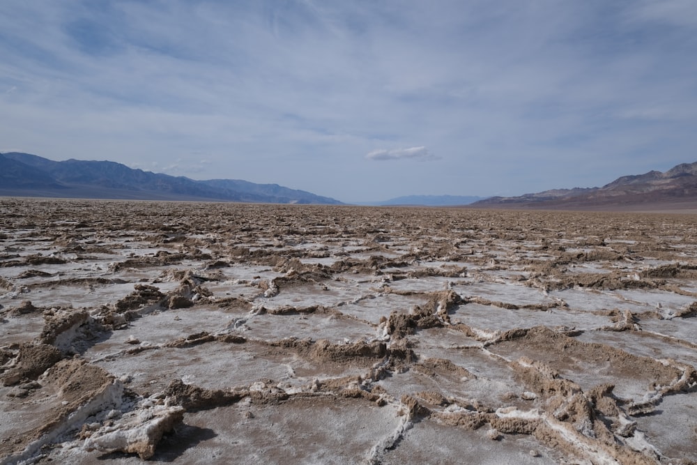 a barren landscape with mountains in the distance