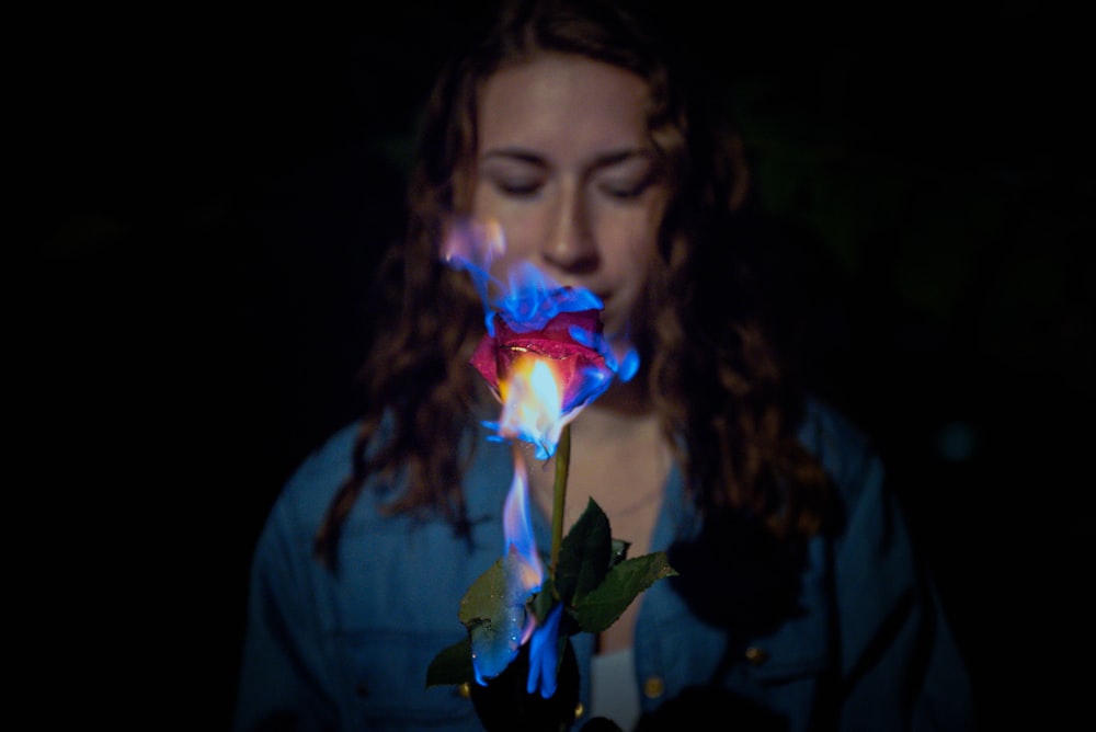 a woman holding a rose in her hands