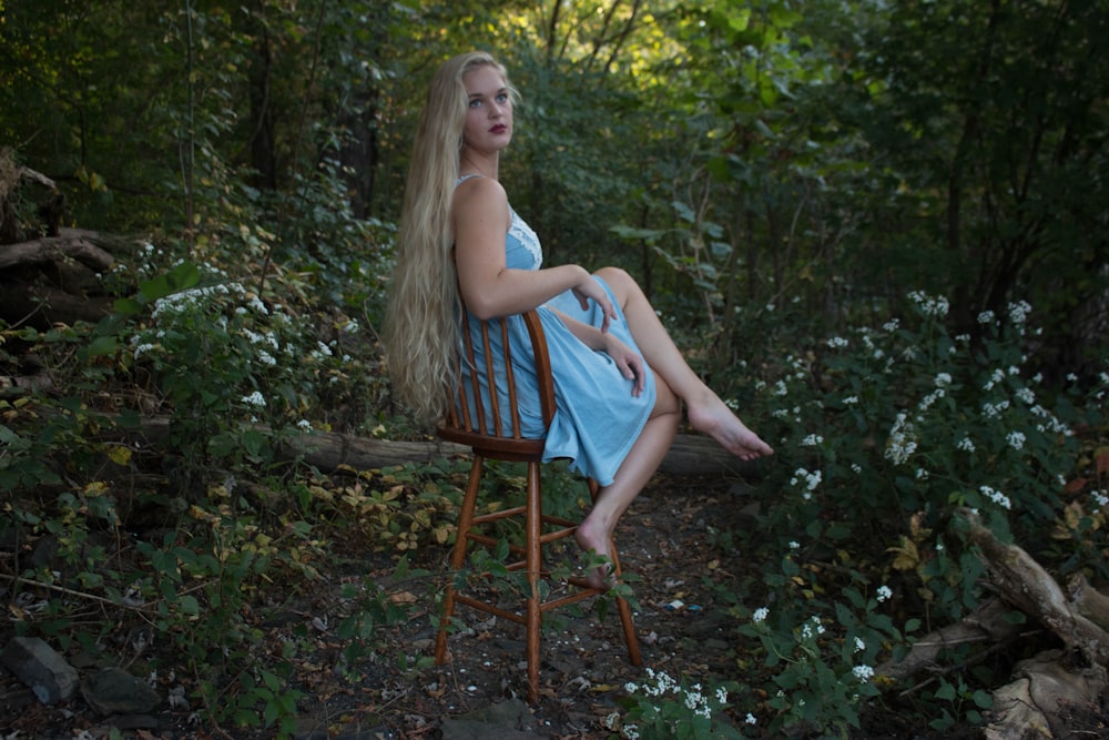 Una donna seduta su una sedia nel bosco