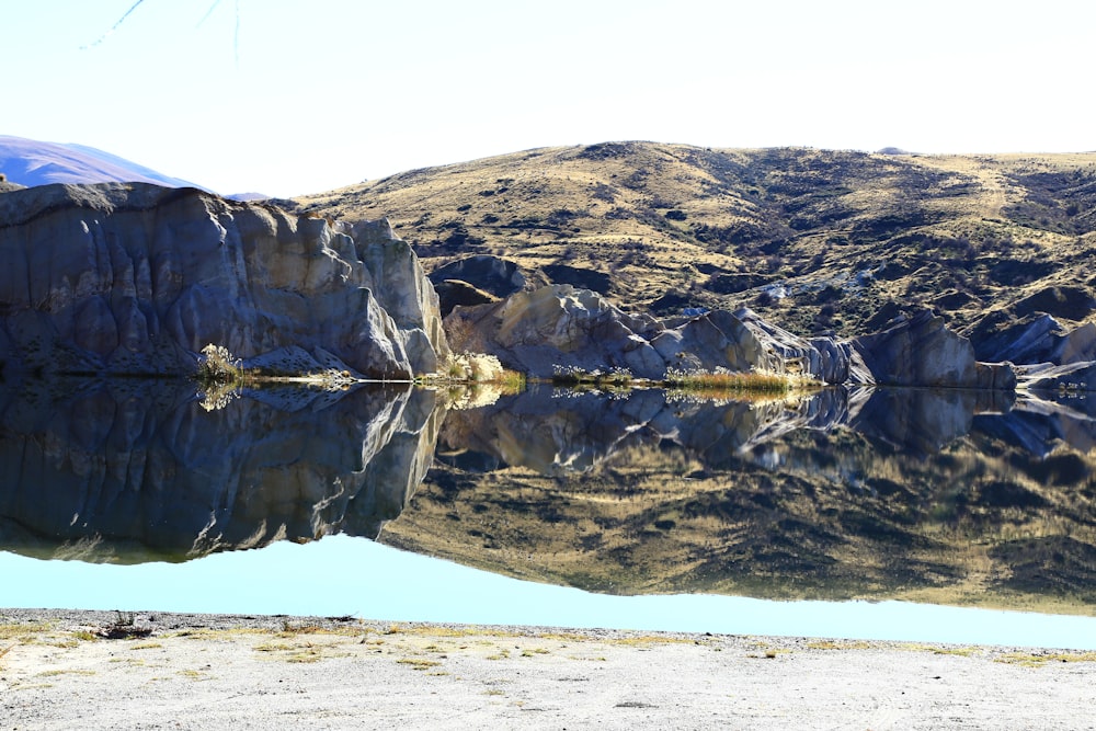 person standing on white sand near brown mountain during daytime