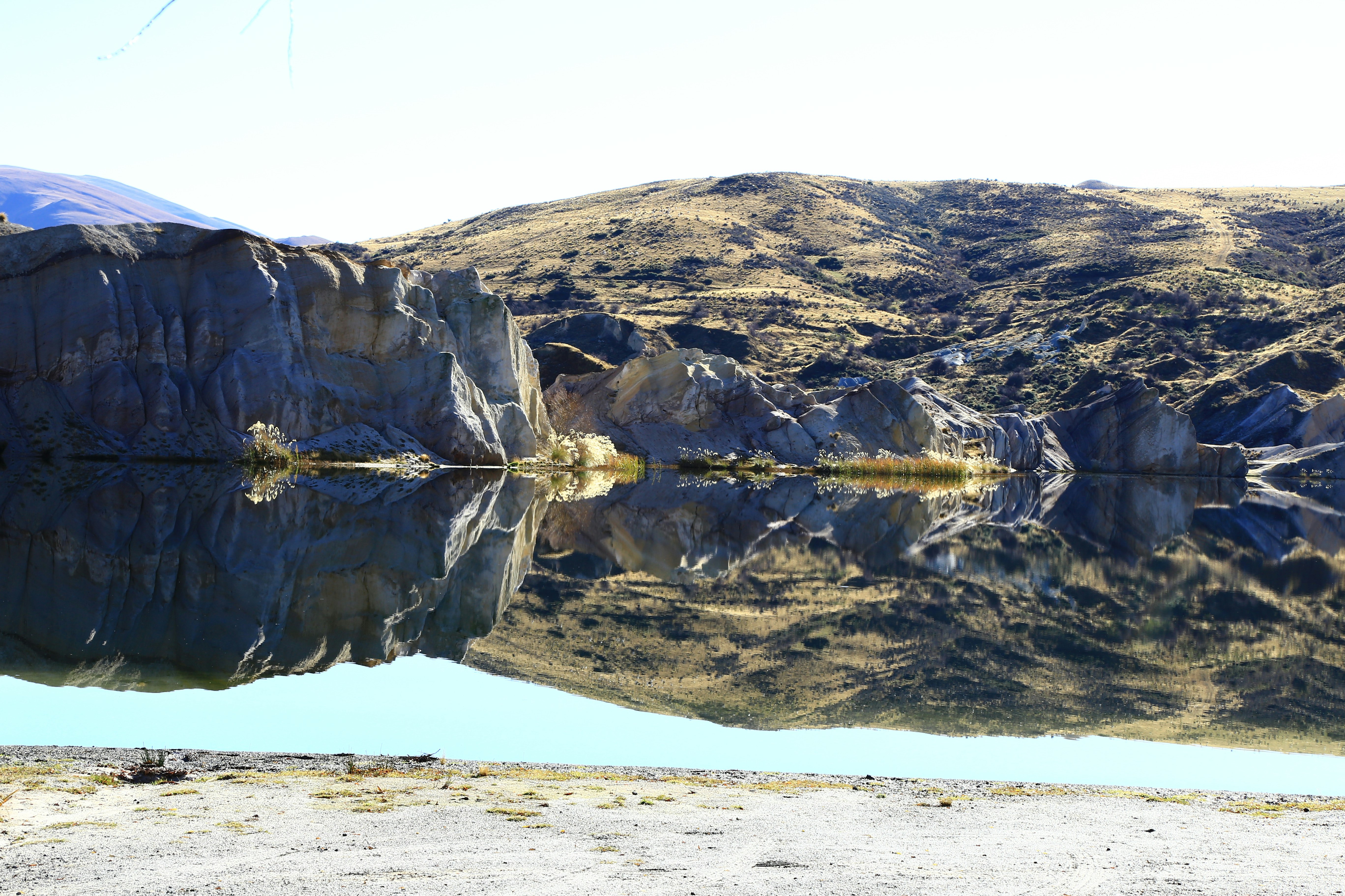 person standing on white sand near brown mountain during daytime