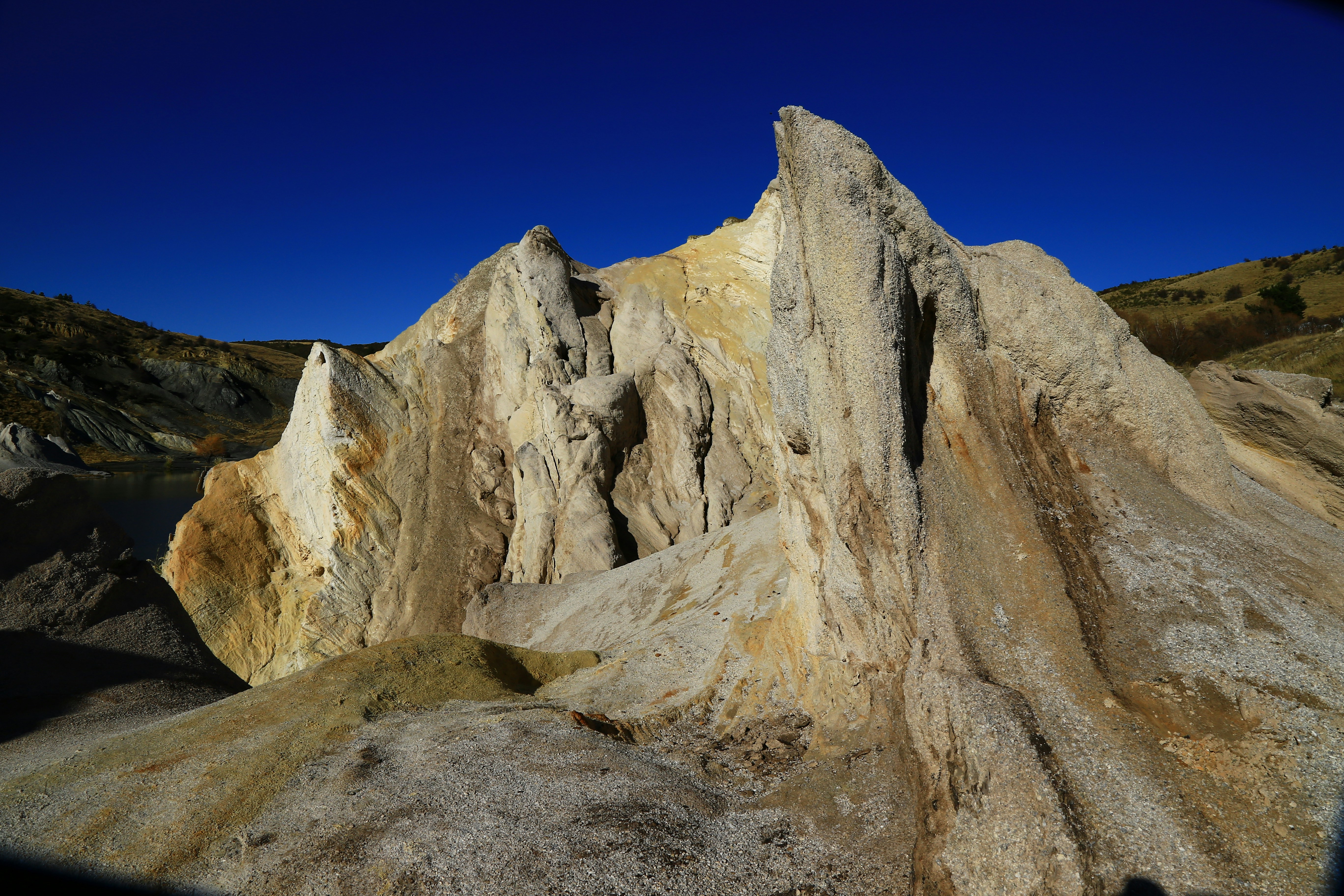 brown rock formation under blue sky during daytime sculptural teams background