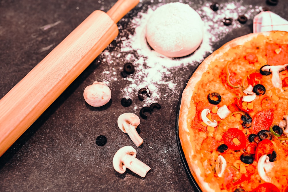 a pizza sitting on top of a table covered in toppings