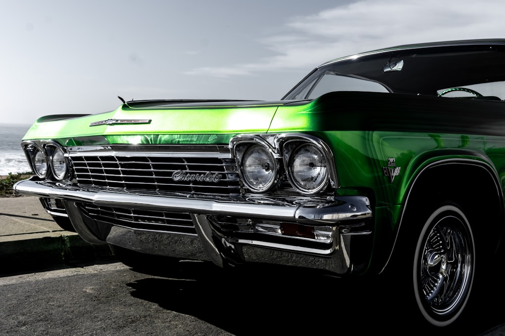 green car on gray asphalt road under gray sky