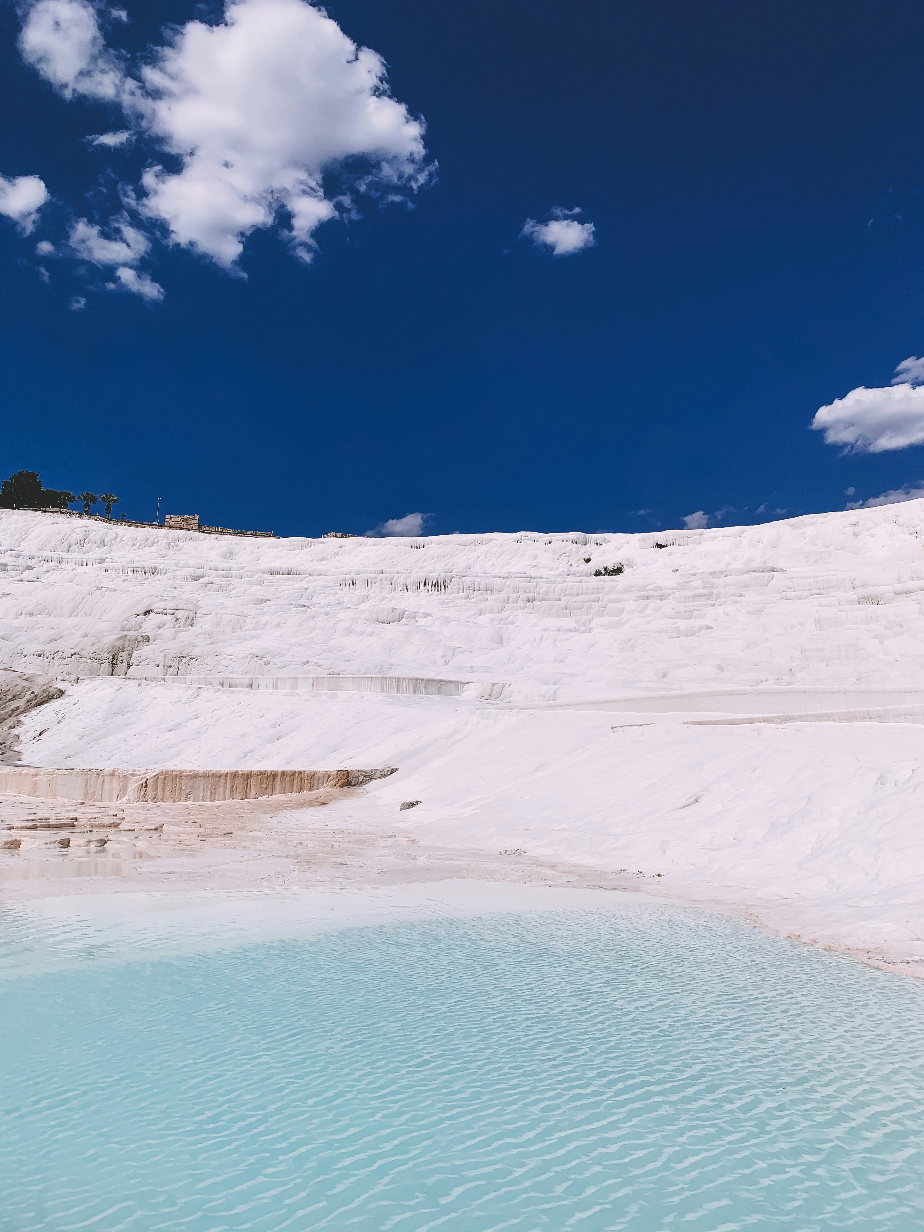 uma piscina de água no meio de uma colina coberta de neve