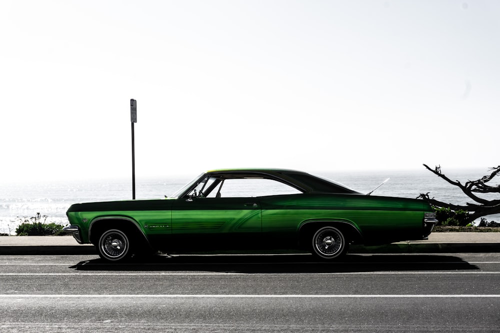 green coupe on gray asphalt road