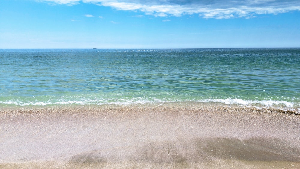 a view of the ocean from a sandy beach