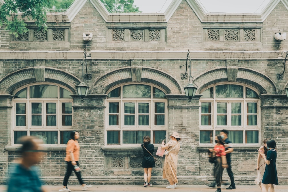 people standing in front of brown concrete building during daytime