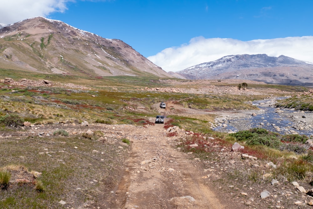 a dirt road with a mountain in the background