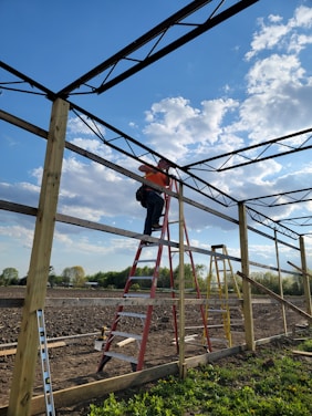 A skilled craftsman repairing a steel structure in a sunny outdoor setting.