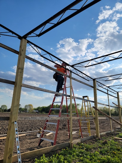 A skilled craftsman repairing a steel structure in a sunny outdoor setting.