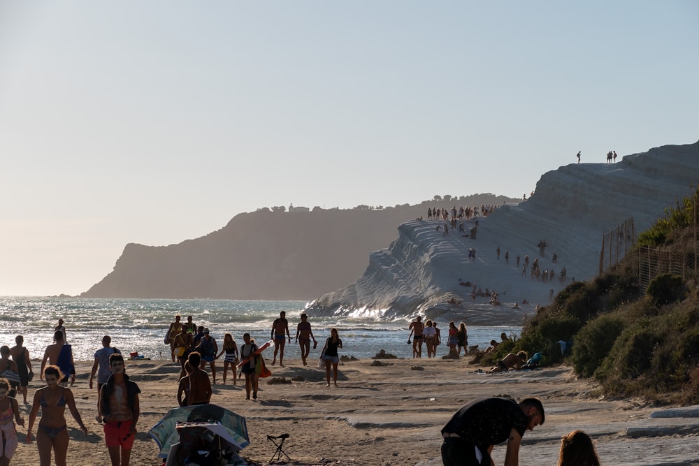 a group of people standing on top of a sandy beach