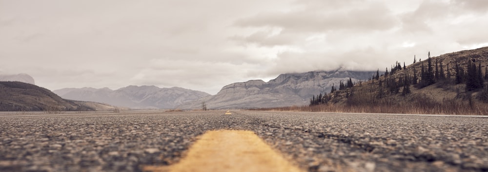 an empty road in the middle of a mountain range