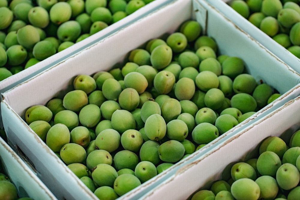 fruits verts dans une caisse en plastique blanc