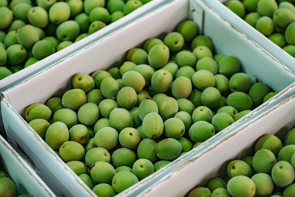 Frutos verdes en caja de plástico blanco