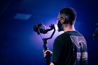 a man holding a camera and a tripod