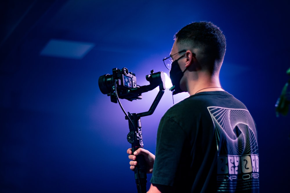 a man holding a camera and a tripod