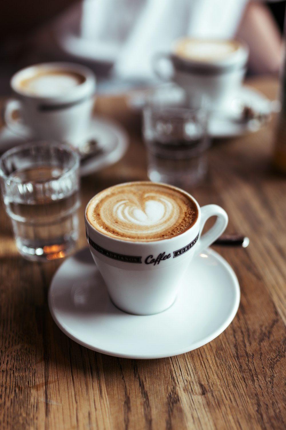 un capuchino en un platillo sobre una mesa de madera