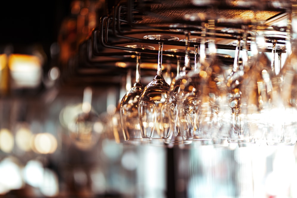 a bunch of wine glasses hanging from a rack