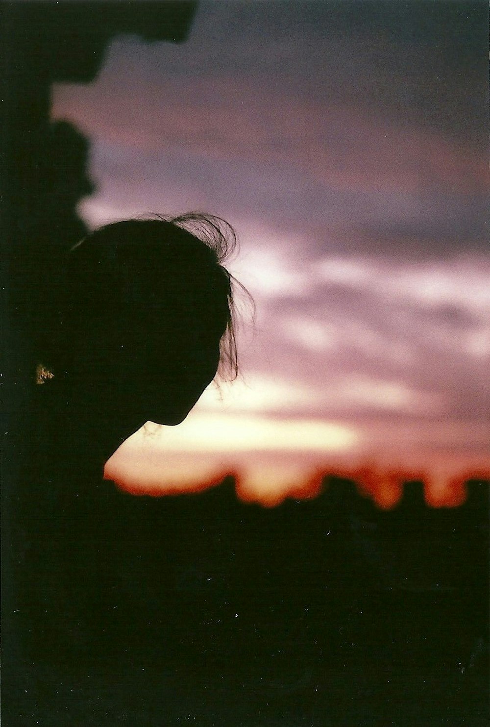 a silhouette of a person in front of a sunset