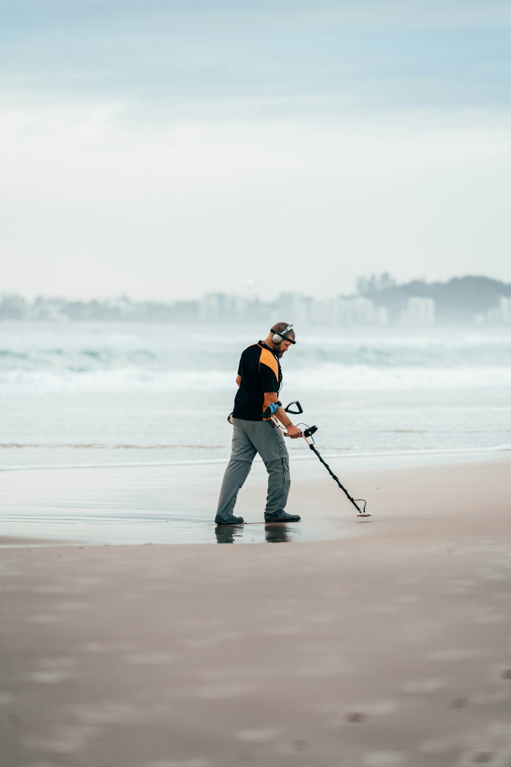 Ein Mann am Strand mit einer Angelrute spazieren