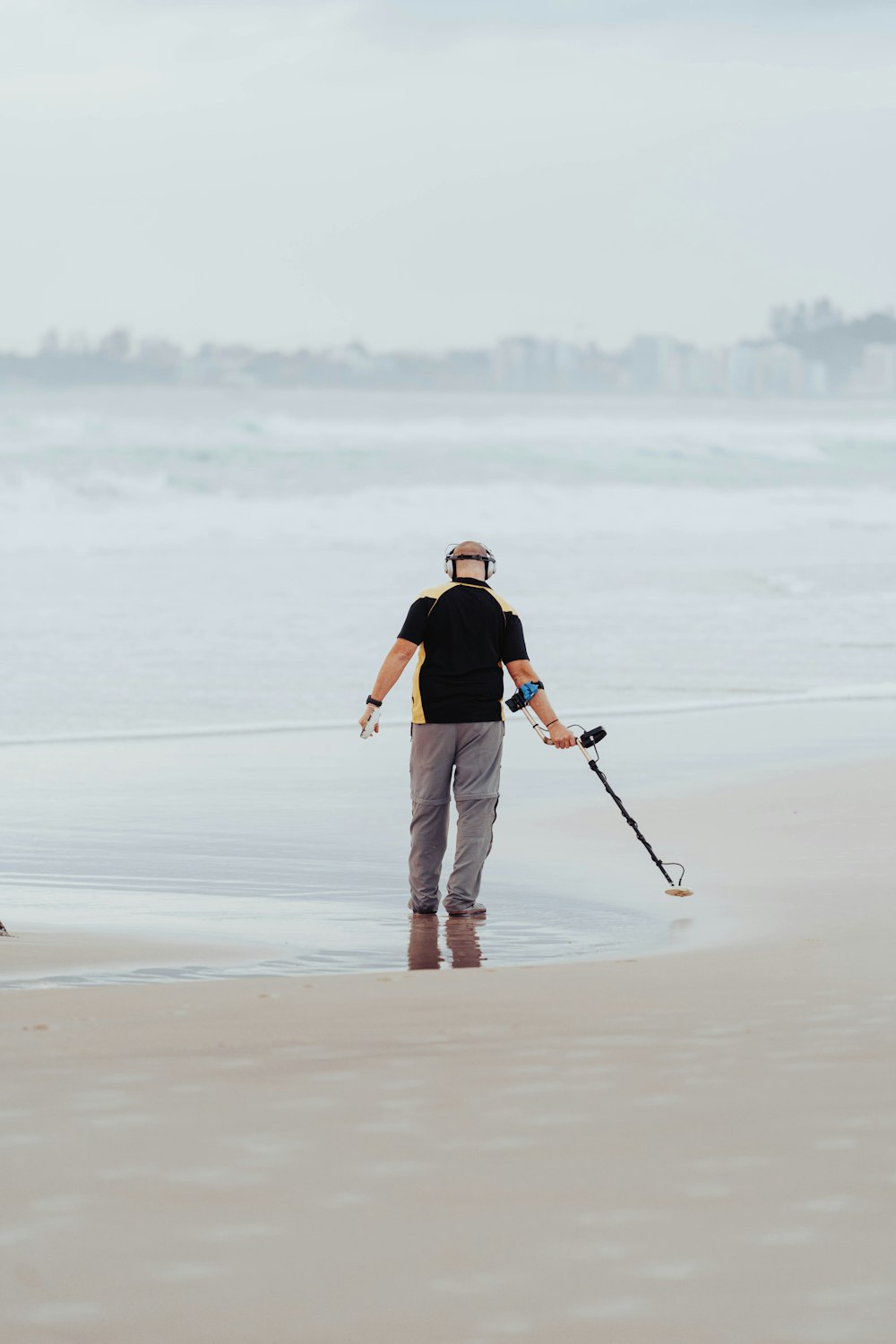 Ein Mann steht auf einem Sandstrand am Meer