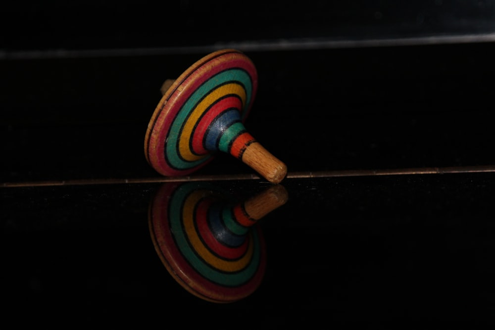 a wooden toy sitting on top of a black surface
