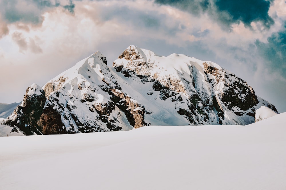 snow covered mountain under cloudy sky during daytime