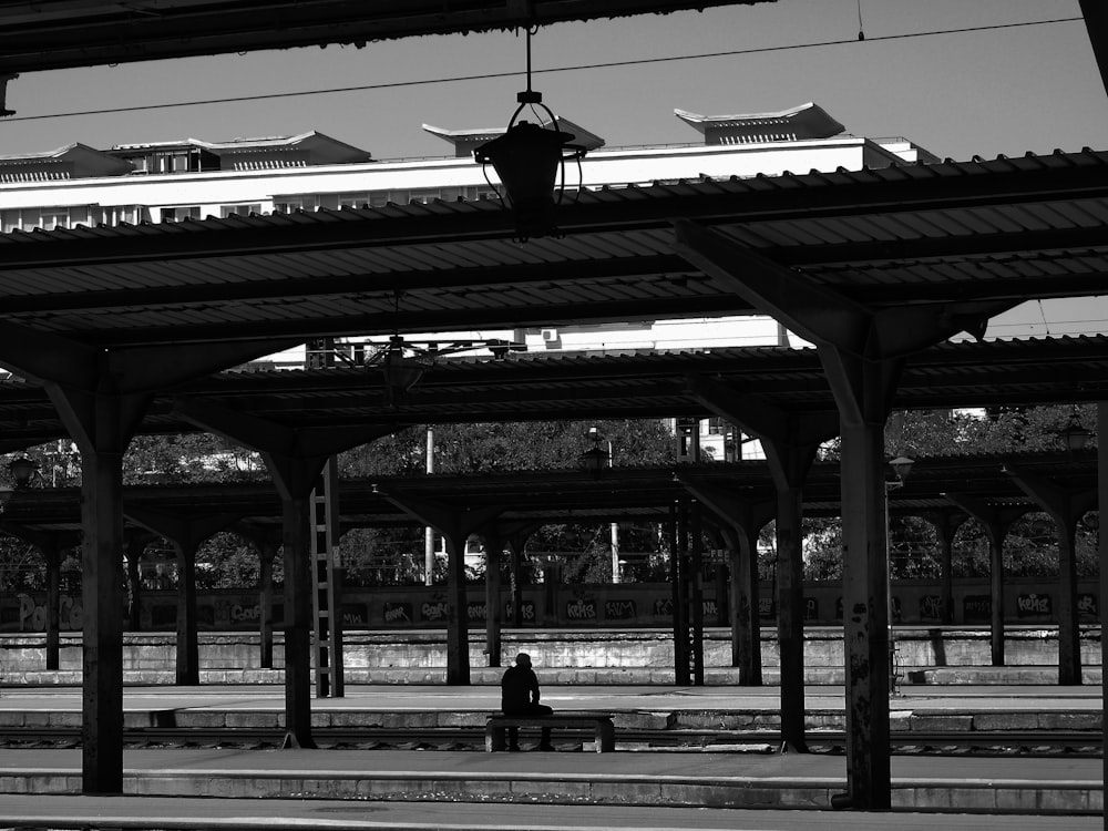 Eine Person, die auf einer Bank in einem Bahnhof sitzt