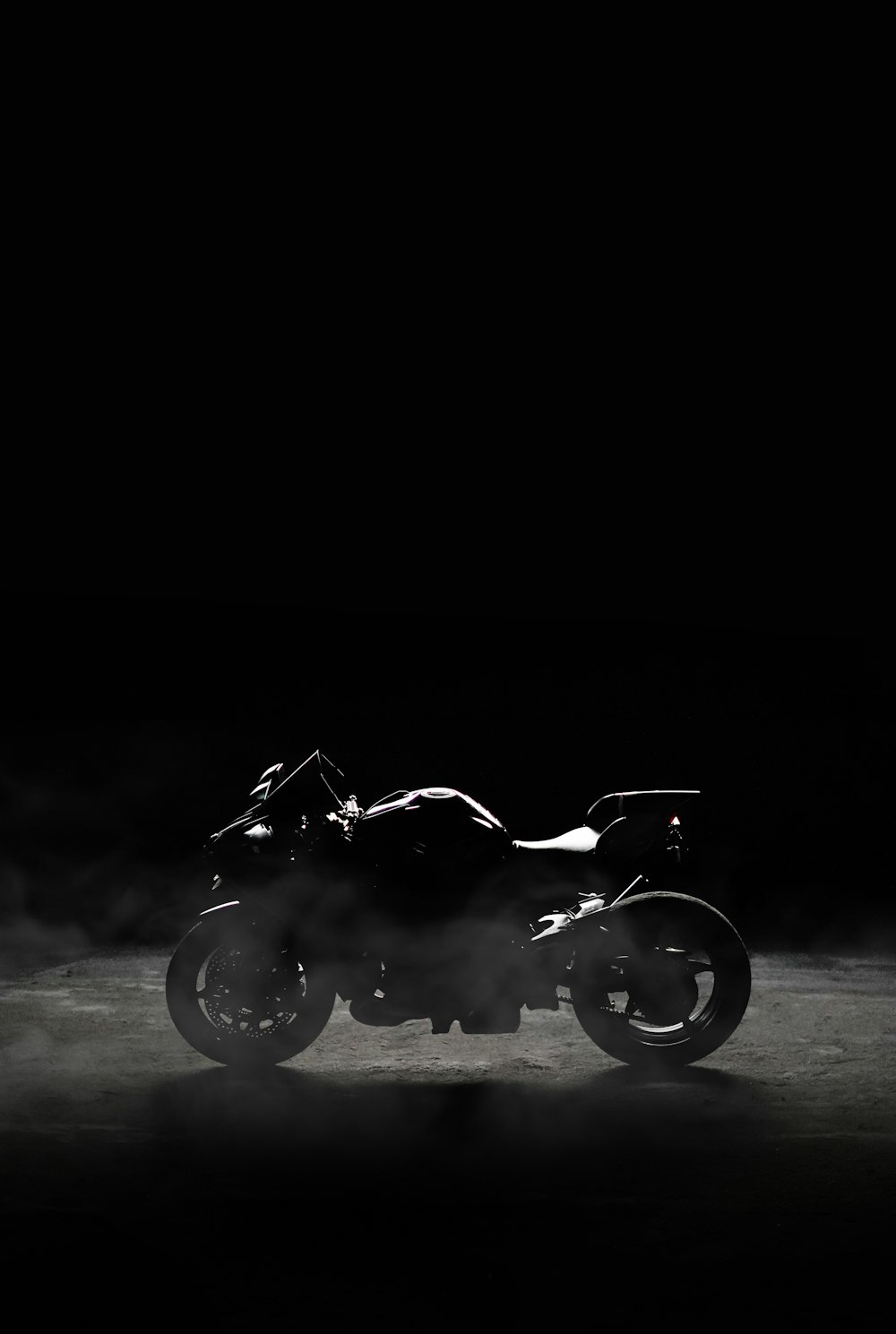 Una foto en blanco y negro de una motocicleta en la oscuridad