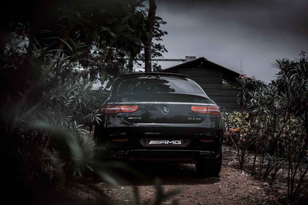 a black car parked in front of a house