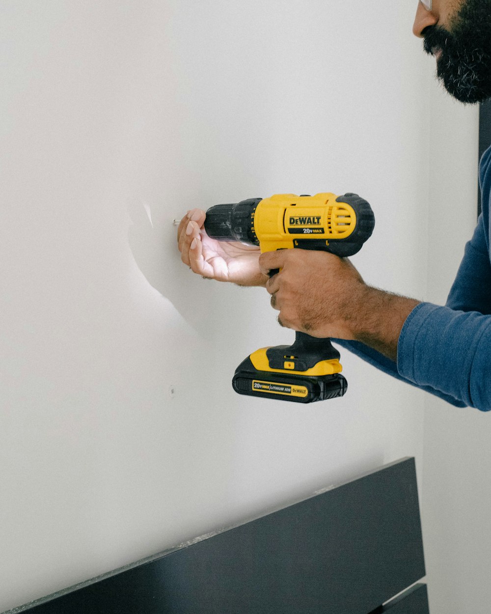 a man is holding a drill and a cordless drill